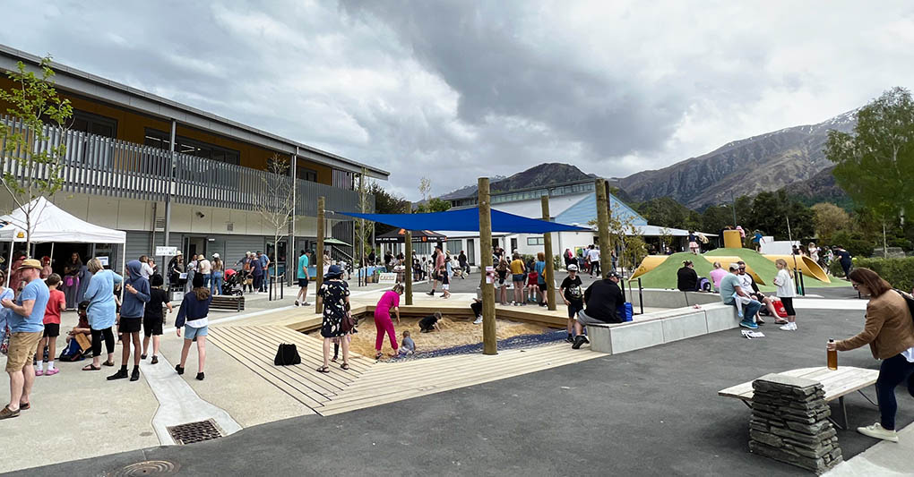 Completed Arrowtown School playground with climbing equipment, shade sails, seating and mountain views.