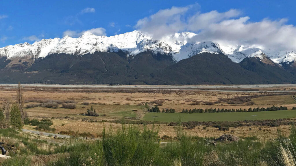 Snow-covered mountains and open rural landscape near the Paradise Road development site in Glenorchy.