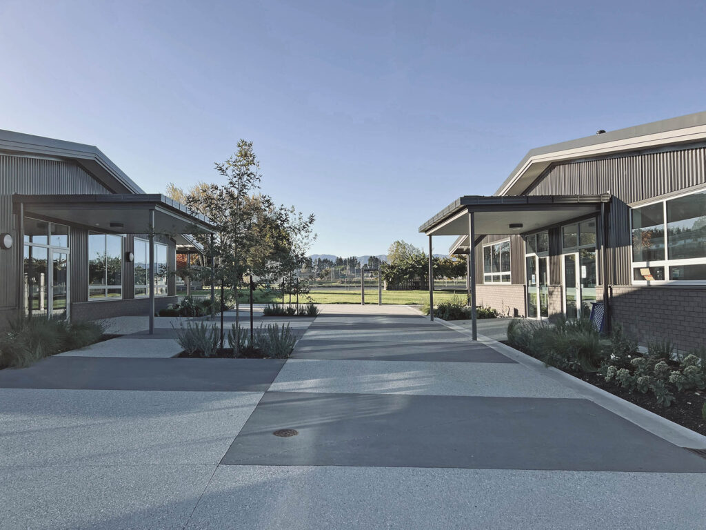 Completed Maniototo Area School courtyard with covered walkways, paved circulation and landscaped planting beds.