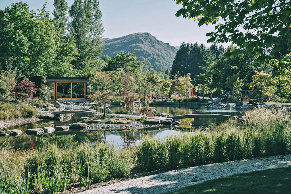 Garden pavilion overlooking interconnected ponds, stepping stones and lush planting at Millbrook Mountain Garden.