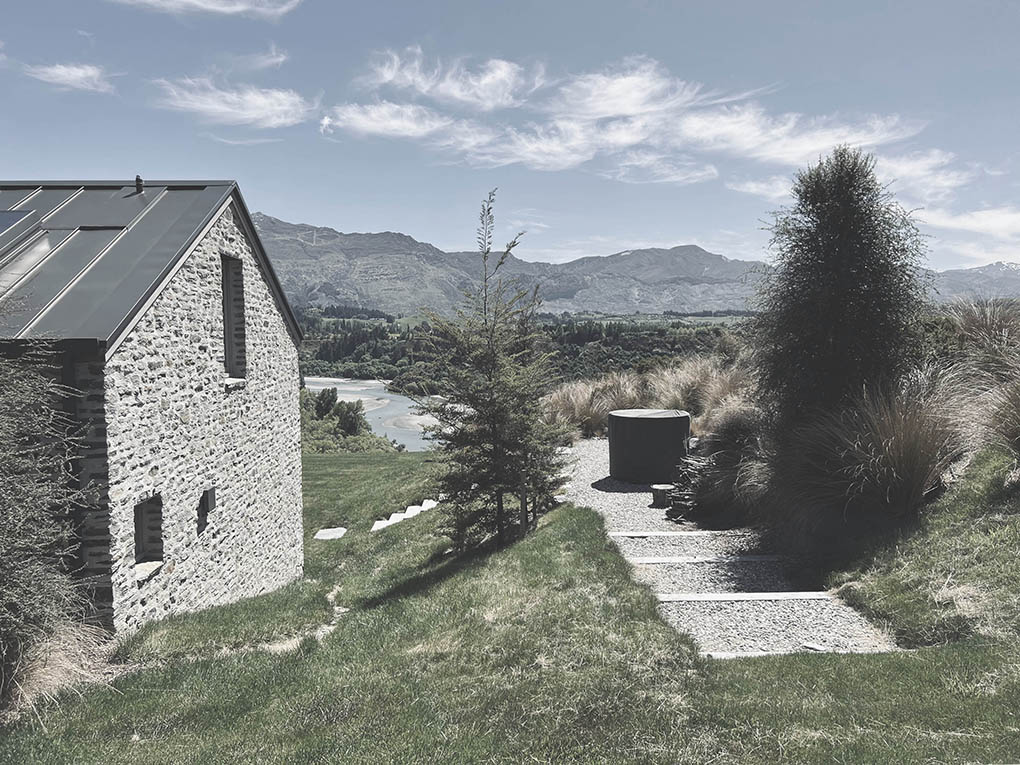 Gravel path and native planting beside Shotover River House leading toward the river landscape.