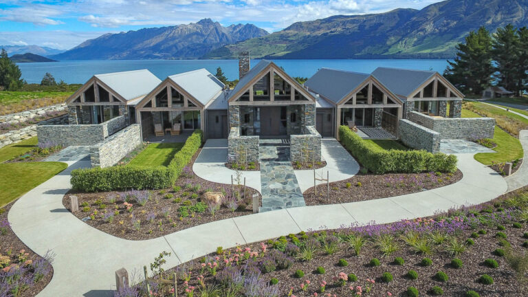 Elevated view of Blanket Bay Villas with curved paths, structured hedges, perennial gardens and Lake Wakatipu beyond.