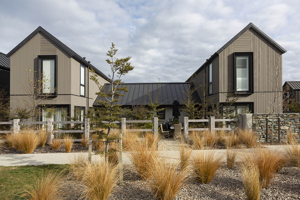 Station View homes framed by tussock planting, post-and-rail fencing and stone landscape walls.
