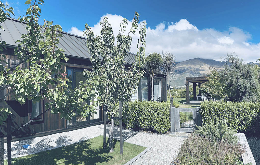 Garden courtyard at Wānaka Barn House with landscaping and mountain views.